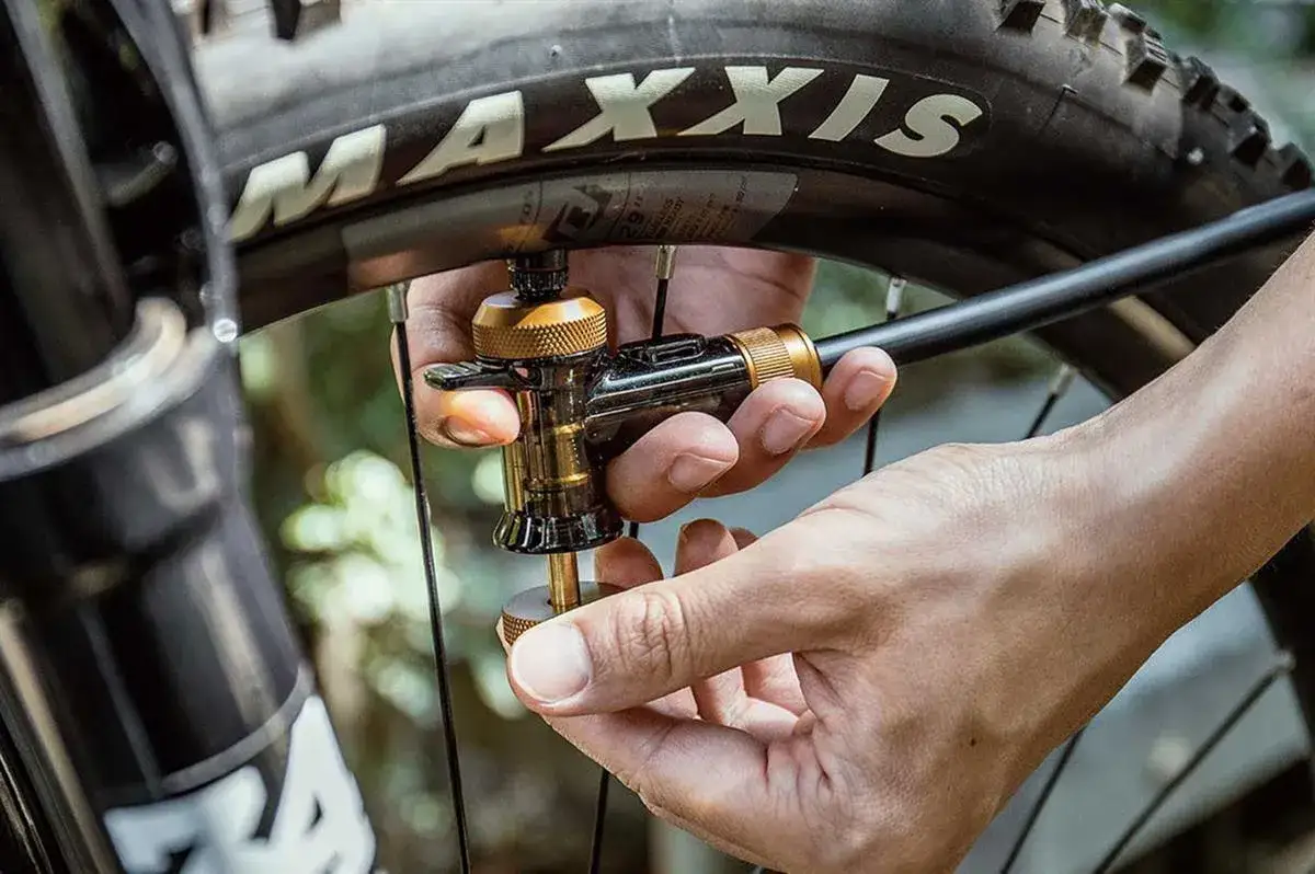 Rowerzysta mierzący ciśnienie w oponie 27.5 cala