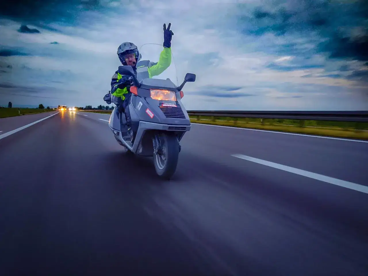 Skuter 125 na autostradzie wyprzedzany przez TIRa